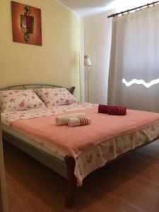 ein Bett mit einer rosa Decke und Kissen darauf in der Unterkunft Apartments 4M in Gornji Karin