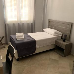 een kleine slaapkamer met een bed en een stoel bij Stanza vacanza lo stadio in Sibari