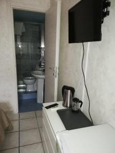 eine Küche mit einem Waschbecken und einem TV an der Wand in der Unterkunft B & B AMICI DELL'ETNA in Nicolosi