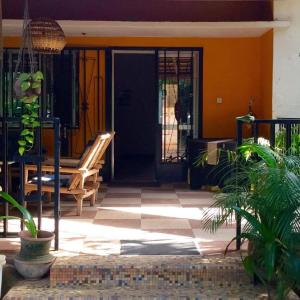 une porte d'entrée d'une maison avec un banc et une terrasse couverte dans l'établissement Auberge Djamilla, à Bamako