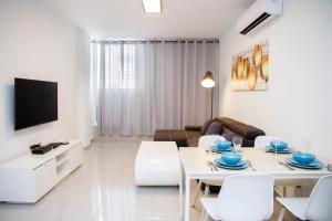 a white living room with a white table and chairs at Apartments4you Maya in Bat Yam