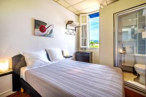 a bedroom with a bed and a bathroom with a window at Hôtel des Moulins in Allauch