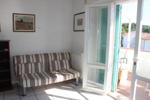 sala de estar con sofá y puerta corredera de cristal en BILO FRANK - Delizioso bilocale con terrazzo vista mare, en Numana