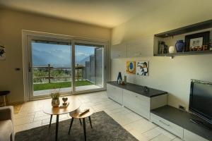 een woonkamer met een groot raam en een televisie bij L'Atelier du Temps - A&G Apartment in Aosta