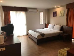 a hotel room with a bed and a desk at Floral Shire Suvarnabhumi Airport - SHA Extra Plus in Lat Krabang
