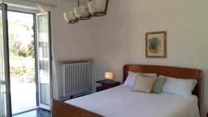 a bedroom with a bed and a glass door with a window at B & B Abbadia in Monesiglio