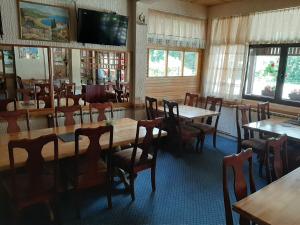 una sala da pranzo con tavoli, sedie e TV a schermo piatto di Restoran i sobe "Tocak" a Doboj