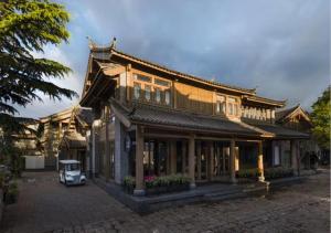 an asian style building with a car parked in front at LUX* Tea Horse Road Lijiang in Lijiang