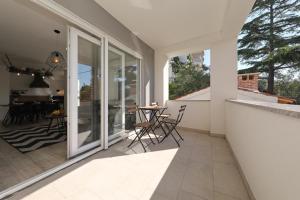 a patio with chairs and a table on a balcony at Apartments Ivanov in Zadar