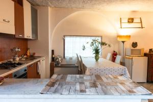 a kitchen with a table with a vase on it at Hiša Hrastovlje - Countryside House in Hrastovlje +12 photos
