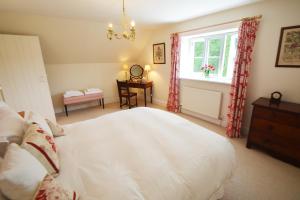 ein Schlafzimmer mit einem großen weißen Bett und einem Fenster in der Unterkunft Woodland Cottage in South Molton + 12 Fotos