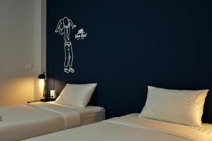 チャンタブリーにあるBlue Bed Hotelの青い壁の部屋にベッドが2つある