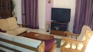 a living room with a couch and a flat screen tv at Haus Maria in Nea Potidaea