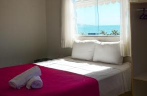 una cama con una toalla delante de una ventana en Hotel Pousada Maravista, en Natal
