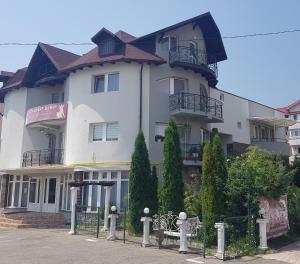 a large white building with a balcony at Pensiunea Beny in Târgu Jiu