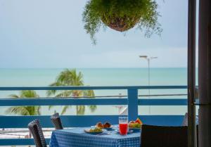 a table with a plate of food and a glass of juice at Hotel Pousada Maravista in Natal