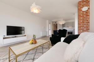 a living room with a white couch and a tv at Apartments Ivanov in Zadar