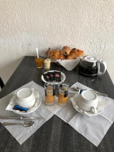 uma mesa com um prato de comida e uma tigela de pão em Hôtel Le Pescadou em Argelès-sur-Mer