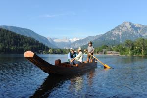 three people sitting in a boat on a lake at SPA Hotel Erzherzog Johann in Bad Aussee