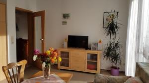 sala de estar con TV y mesa con flores en Ferienwohnung Richter en Tharandt