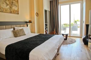 a bedroom with a large bed and a balcony at Hôtel La Villa Cap d’Antibes in Juan-les-Pins