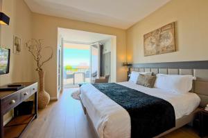 a bedroom with a large bed and a balcony at Hôtel La Villa Cap d’Antibes in Juan-les-Pins