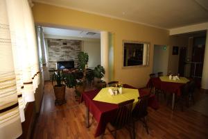a dining room with two tables with red table cloth at Bar Malwa in Aleksandrów Łódzki