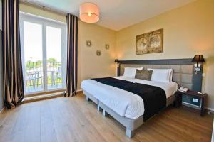 a bedroom with a large bed and a large window at Hôtel La Villa Cap d’Antibes in Juan-les-Pins