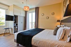 a bedroom with a large bed and a large window at Hôtel La Villa Cap d’Antibes in Juan-les-Pins