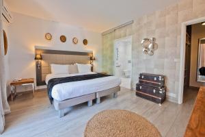 a bedroom with a large bed and a bathroom at Hôtel La Villa Cap d’Antibes in Juan-les-Pins