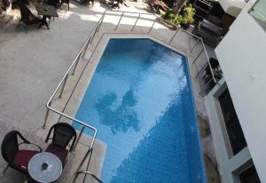 einen Blick über einen blauen Pool mit 2 Stühlen in der Unterkunft New Farah Hotel in Agadir
