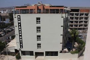 ein weißes Gebäude mit einem Schild an der Seite in der Unterkunft New Farah Hotel in Agadir