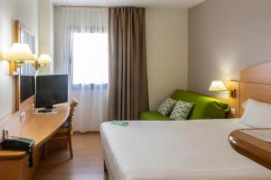 a hotel room with a bed and a television at Campanile Madrid Alcalá de Henares in Alcalá de Henares