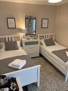 2 camas en una habitación con espejo y lavabo en The White Swan Hotel, en Duns