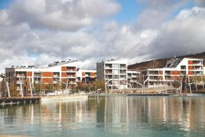 a group of buildings next to a body of water at Coqueto apartamento Las Margas Golf in Sabiñánigo