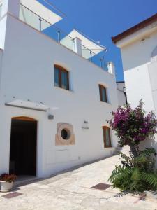 a white building with a door and flowers at La Casa di Gino in San Nicola