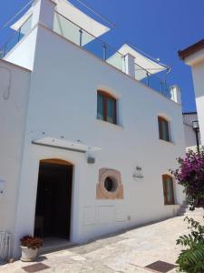 un edificio bianco con porta e balcone di La Casa di Gino a San Nicola