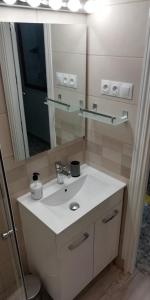 een badkamer met een witte wastafel en een spiegel bij Calle Rio Trueba 11 Bajo D in Torremolinos