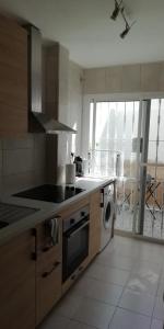 a kitchen with a stove top oven next to a dishwasher at Calle Rio Trueba 11 Bajo D in Torremolinos