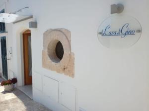 a bathroom with a toilet in a white wall at La Casa di Gino in San Nicola