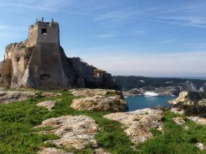 a castle on top of a hill with a body of water at La Casa di Gino in San Nicola