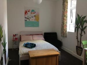 een kleine slaapkamer met een bed en een stoel bij Igloo Hybrid in Nottingham