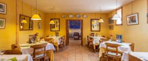 a restaurant with white tables and chairs and yellow walls at Hotel Rural Mas Fontanelles in Biar