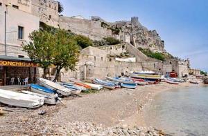 a group of boats sitting on a beach near the water at La Casa di Gino in San Nicola