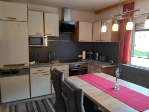 a kitchen with a wooden table with chairs around it at Haus Waldfriede in Sankt Leonhard im Pitztal