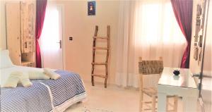 a room with a bed and a table and a ladder at Dakhla Ride Adventures in Dakhla