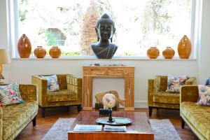 a living room with a statue of a head on a fireplace at Hôtel La Villa Cap d’Antibes in Juan-les-Pins
