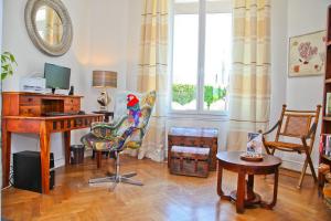 a living room with a desk and a bird sitting on a chair at Hôtel La Villa Cap d’Antibes in Juan-les-Pins