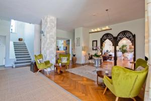 a living room with green chairs and a staircase at Hôtel La Villa Cap d’Antibes in Juan-les-Pins
