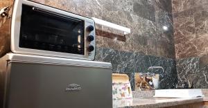a microwave sitting on top of a refrigerator in a kitchen at Dakhla Ride Adventures in Dakhla